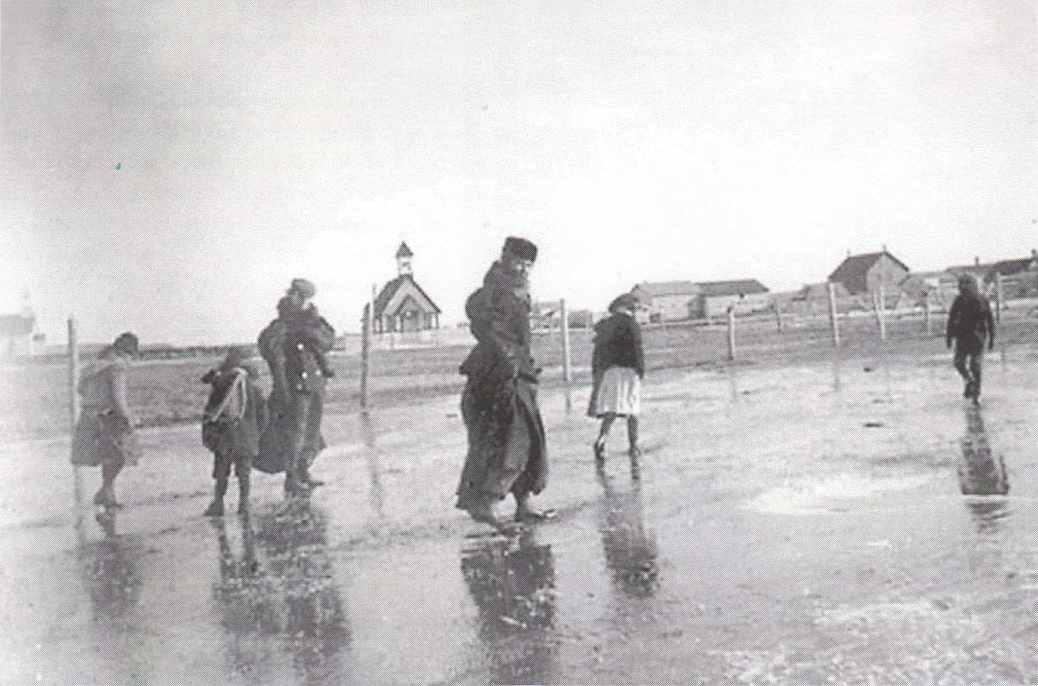 Our little church in a bare field, behind some brave souls making their way through the puddles on a Sunday in 1899: Ethel Beam, Bertie Fry, Mrs. Beam, Mrs. J. Phipps, Dora and Vincent Phipps. That's the Roman Catholic church on the far left.