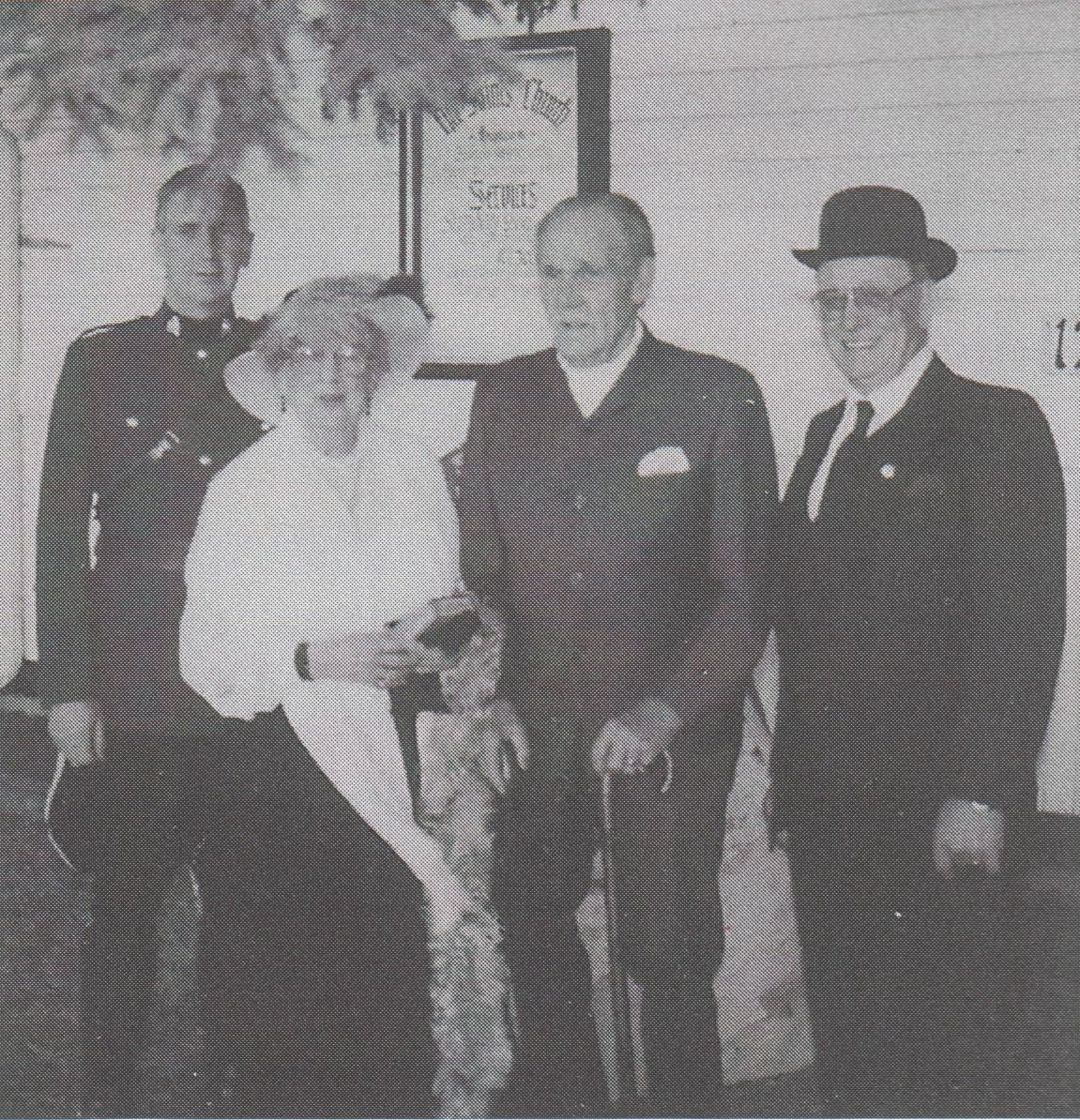 Jim Kerfoot between Mrs. Hill and Leigh Blackwell, with Cst. Ralph Crittenden standing guard.